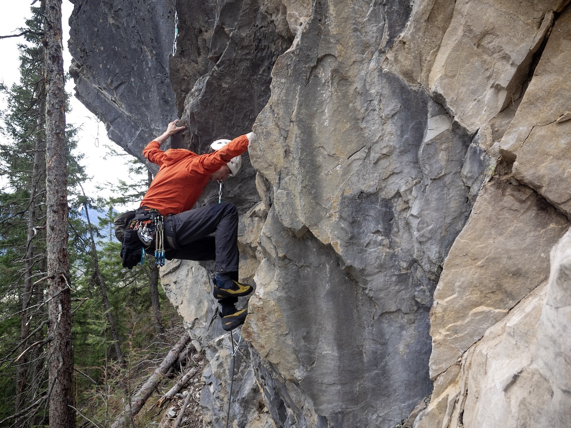 Climber in compact position while adjusting foot.