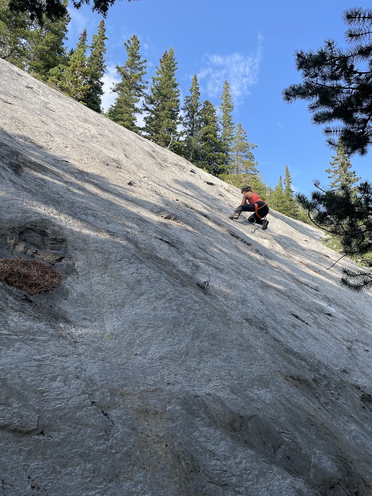 A climber ascending a moderate slab slope.