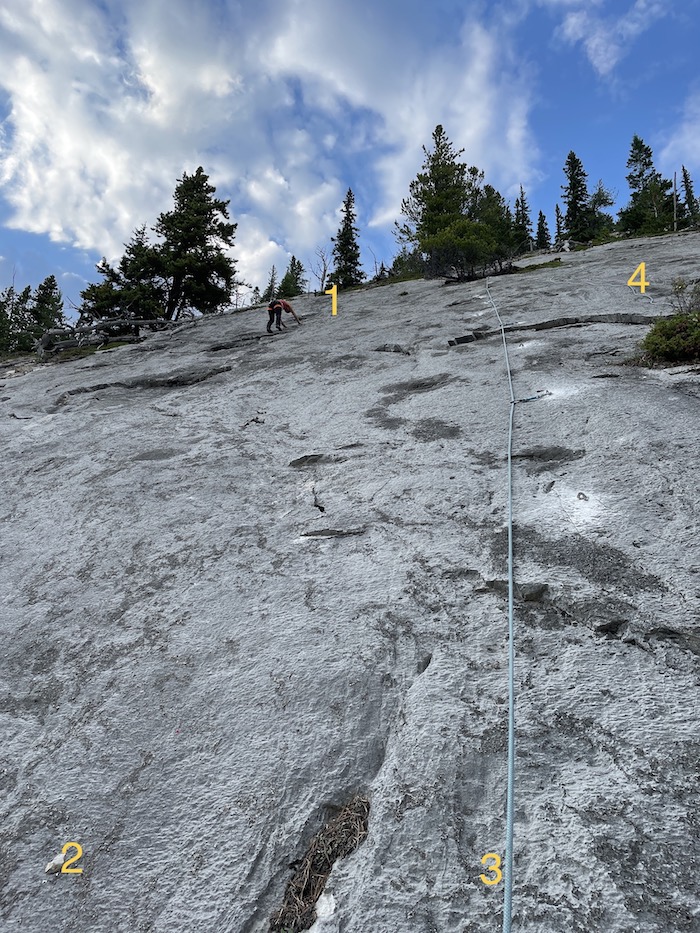 A picture of a cliff with the names of rock climbing routes. Left hand side of the crag.