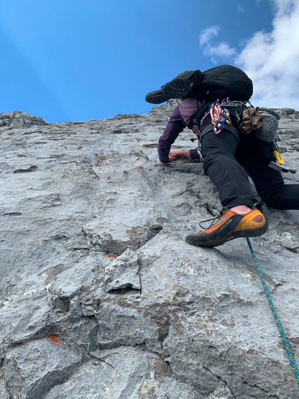 A climber balancing while searching for climbing handholds.